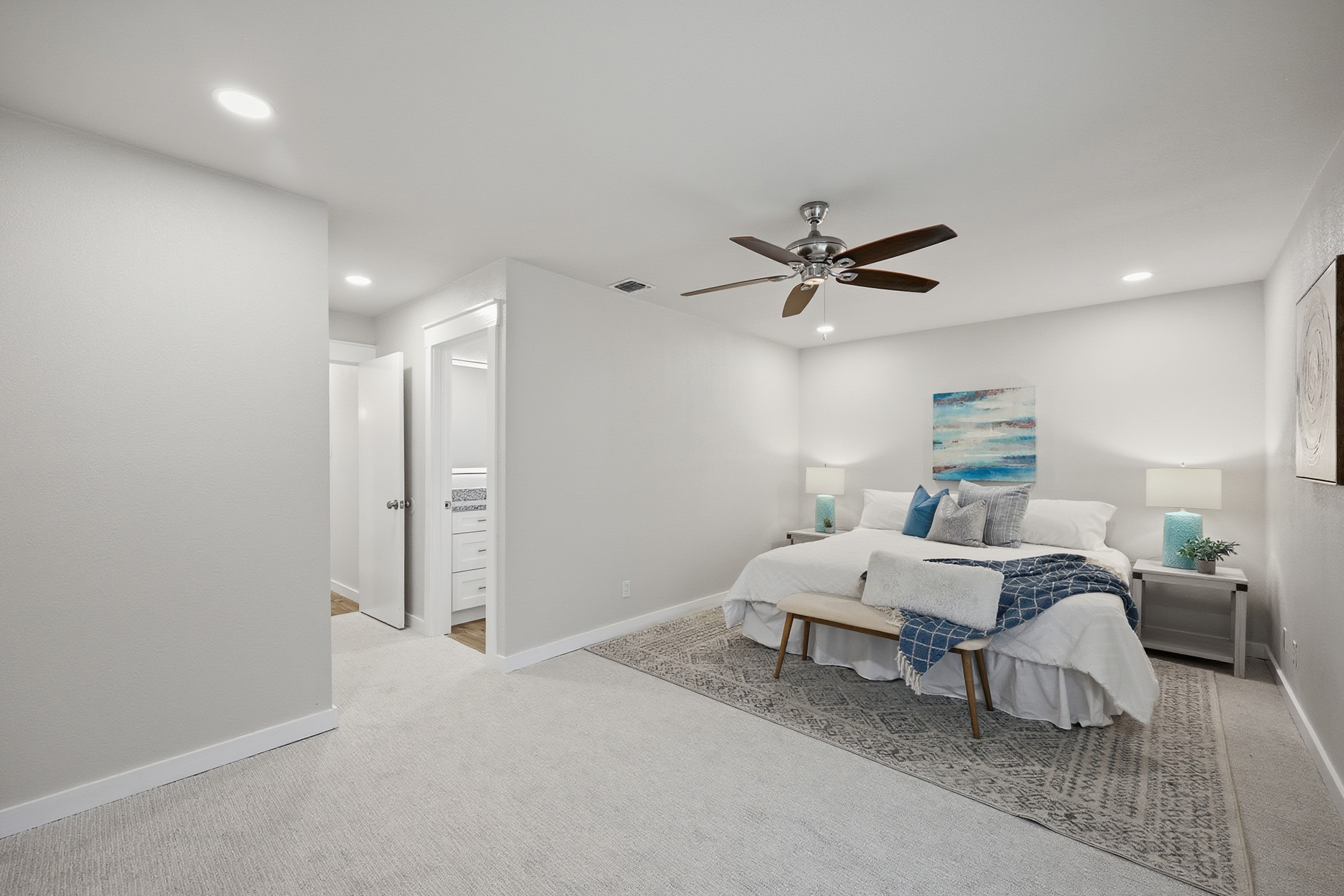 Primary bedroom with walk-through to en-suite bath and recessed lighting